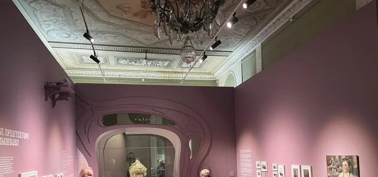 Выставочный зал музея с декоративной аркой экспозиции и витриной в историческом интерьере